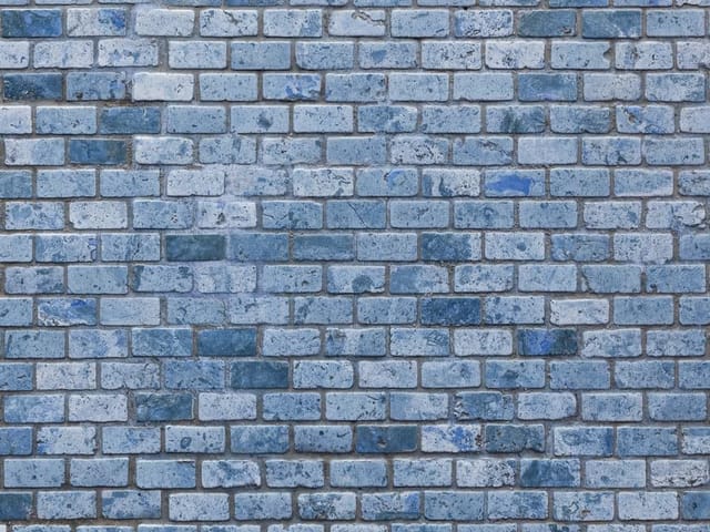 Fototapeta przedstawiająca ścianę z niebieskich cegieł w różnych odcieniach
