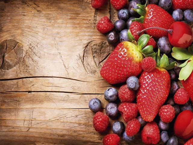 Fototapeta z truskawkami, malinami i jagodami na drewnianym tle