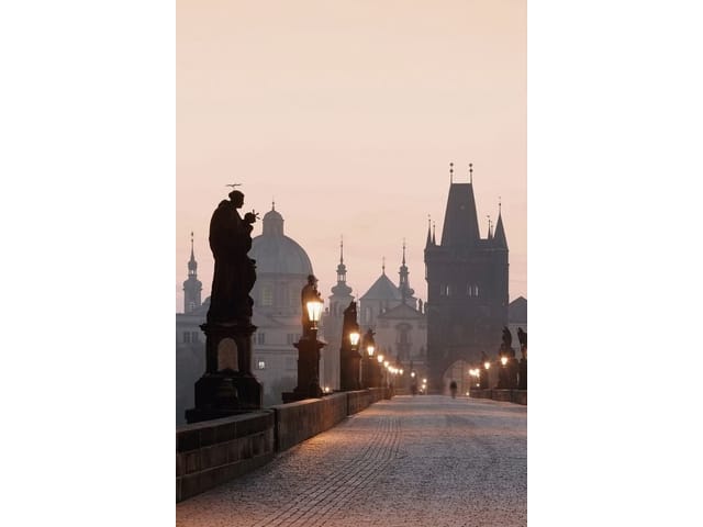 Fototapeta z kamiennym mostem, rzeźbami i latarniami na tle kopuł i wież