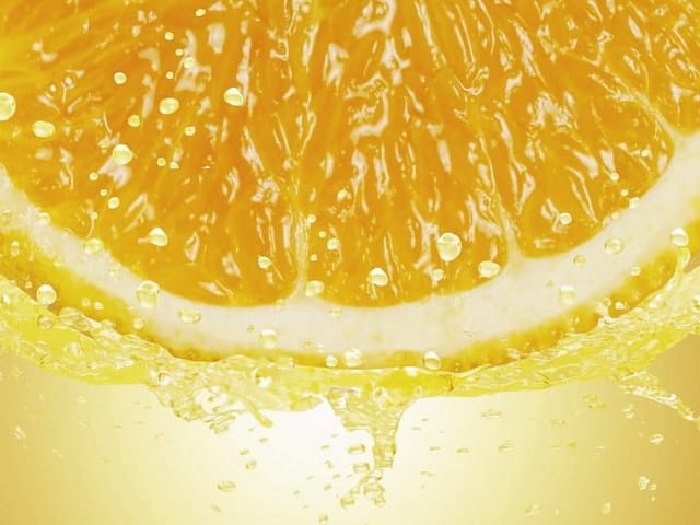 Fototapeta z plasterkiem pomarańczy i kroplami na jasnym tle