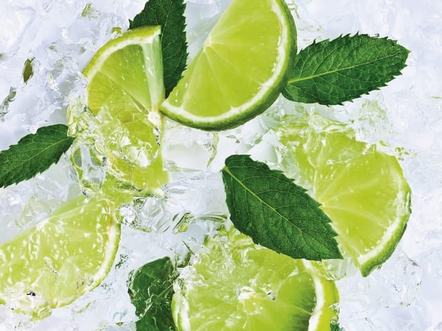 Fototapeta z plasterkami limonki i liśćmi mięty na lodzie