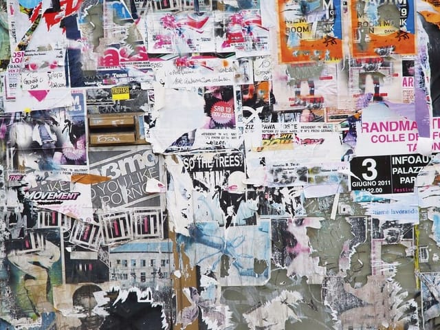 Fototapeta z chaotyczną ścianą pokrytą kolorowymi plakatami i tekstami