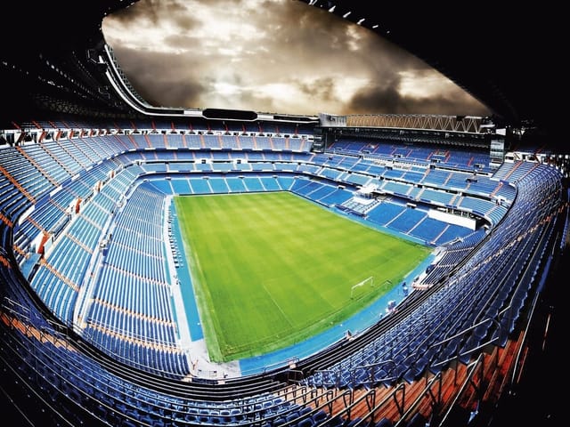 Fototapeta Stadion piłkarski z trybunami (mpn: 1611) Fototapeta przedstawiająca duży stadion piłkarski z pustymi trybunami i zielonym boiskiem