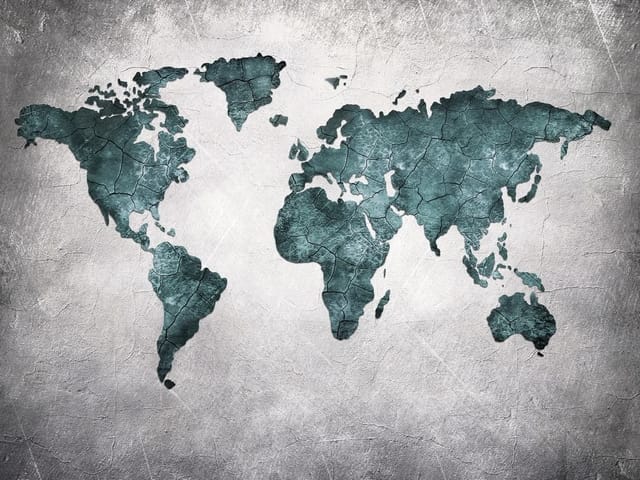 Fototapeta z mapą świata na betonowej ścianie z niebieskimi kontynentami