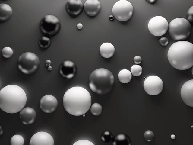 Fototapeta z czarno-białymi kulami o różnych rozmiarach na ciemnym tle