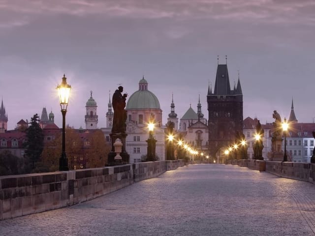 Fototapeta Most z latarniami i posągami (mpn: 2093) Fototapeta przedstawiająca kamienny most z latarniami i posągami, z wieżami i kopułami w tle.