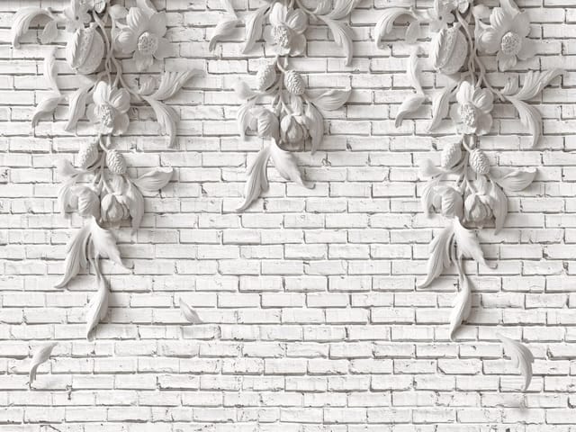 Fototapeta z dekoracyjnymi reliefami kwiatowymi na białej ceglanej ścianie
