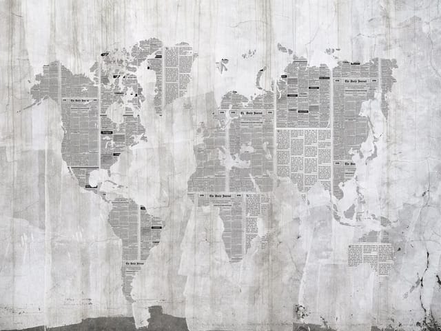 Fototapeta z mapą świata z gazetowych wycinków na szarym tle