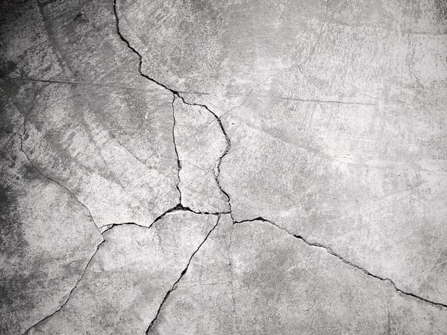 Fototapeta przedstawiająca pęknięcia na szorstkiej betonowej powierzchni