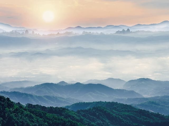 Fototapeta Górski krajobraz z mgłą o zachodzie (kod: 24733) Fototapeta z górskim krajobrazem, mgłą i zachodzącym słońcem