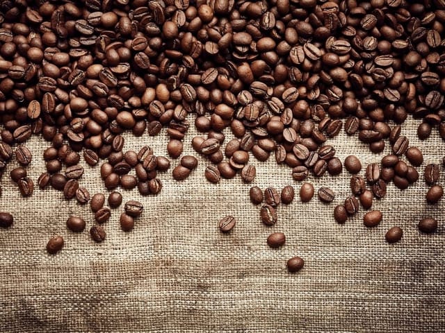 Fototapeta z ziarnami kawy na jutowym tle, różne odcienie brązu