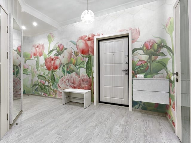 Fototapeta z dużymi kwiatami piwonii i zielonymi liśćmi na jasnym tle