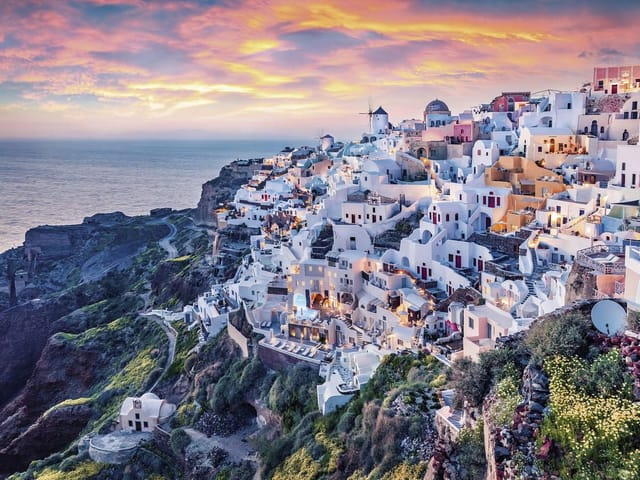 Fototapeta z białymi budynkami na skalistym wzgórzu i morzem w tle