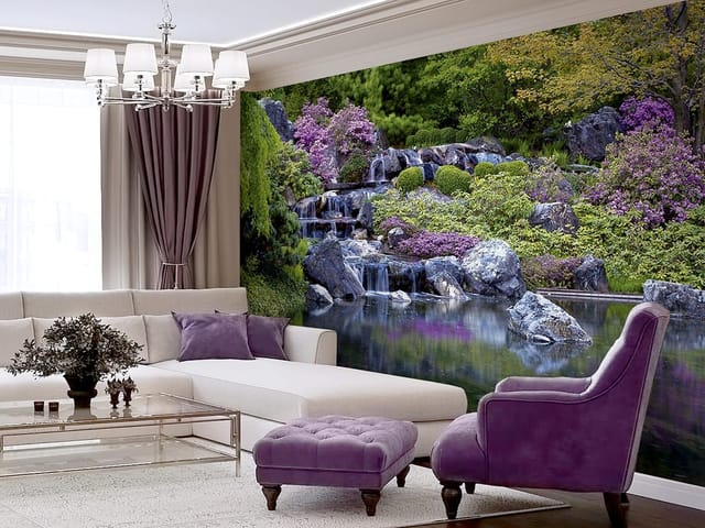 Fototapeta przedstawiająca ogród z wodospadem, kamieniami, zielenią i fioletowymi kwiatami.