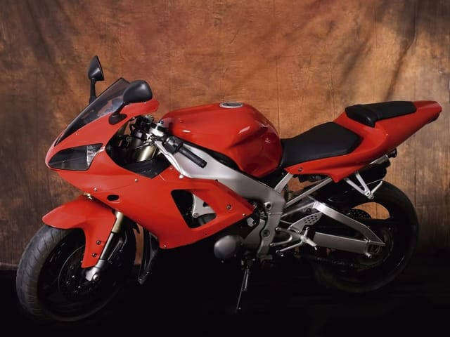 Fototapeta z czerwonym motocyklem sportowym na brązowym tle