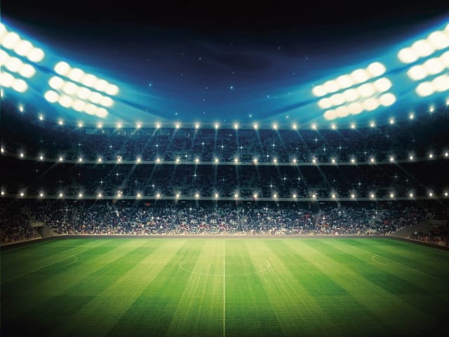Fototapeta Stadion Piłkarski Nocą (mpn: 3342) Fototapeta z oświetlonym stadionem piłkarskim nocą, zielona murawa i widzowie