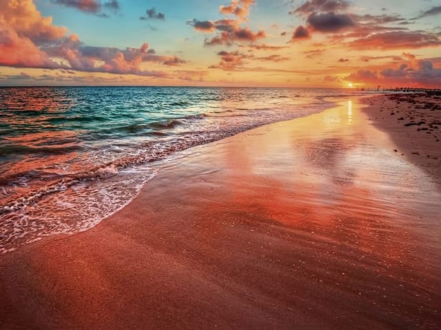 Fototapeta z plażą o zachodzie słońca, fale oceanu i mokry piasek