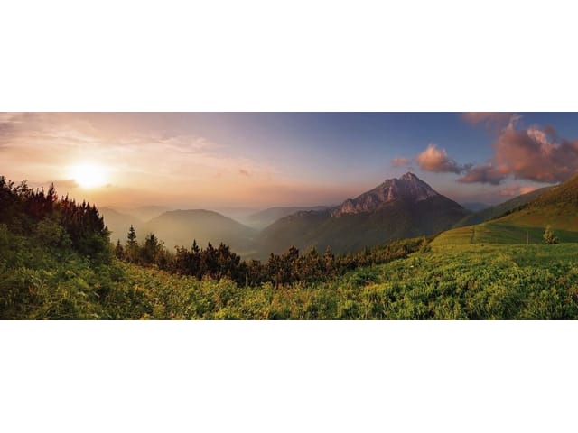 Fototapeta z górskim krajobrazem i zachodzącym słońcem nad łąkami