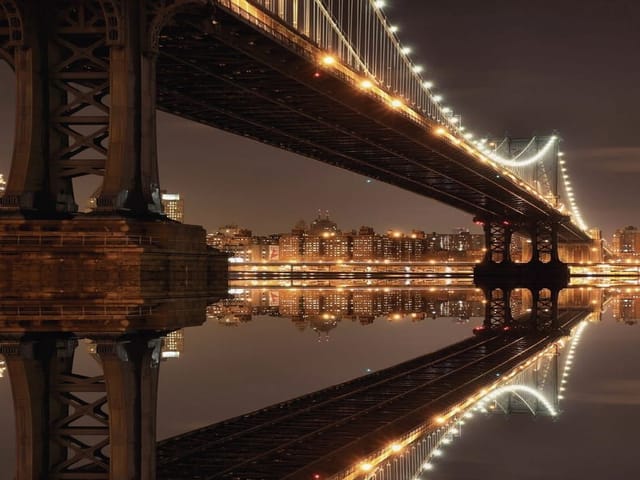 Fototapeta przedstawiająca most z oświetleniem nocnym, miasto i odbicie w wodzie