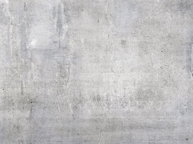Fototapeta przedstawiająca szarą betonową ścianę z fakturą, smugami i pęknięciami