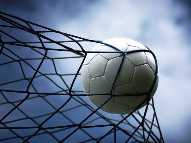 Fototapeta Piłka nożna w siatce bramki (kod: 4930) Fototapeta przedstawiająca piłkę nożną w siatce bramki na tle nieba