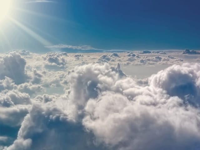 Fototapeta Chmury na tle jasnego nieba (kod: 5751) Fototapeta z puszystymi chmurami i promieniami słońca na niebie