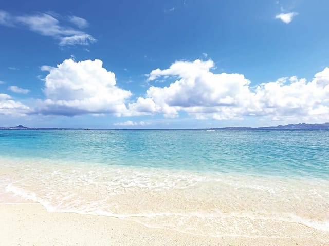 Fototapeta Plaża z Błękitnym Morzem (mpn: 5790) Fototapeta przedstawiająca piaszczystą plażę, błękitne morze i góry na horyzoncie