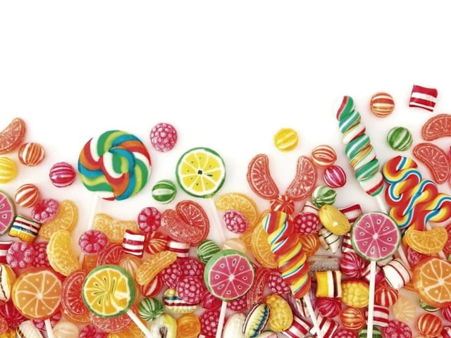 Fototapeta z kolorowymi cukierkami i lizakami na białym tle
