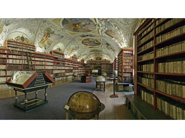 Fototapeta regały z książkami – wielka biblioteka z wysokimi regałami pełnymi książek i ozdobnym sufitem z freskami