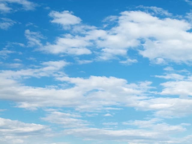 Fototapeta przedstawiająca spokojne niebo z rozproszonymi białymi chmurami i jasnym światłem