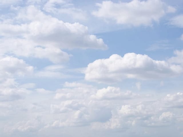 Fototapeta z białymi chmurami na tle niebieskiego nieba, rozproszone światło