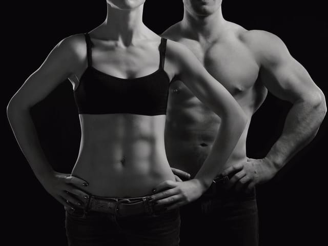 Fototapeta z muskularną kobietą i mężczyzną na czarnym tle