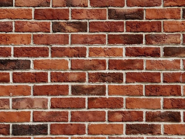 Fototapeta przedstawiająca ścianę z czerwonej cegły z widocznymi spoinami