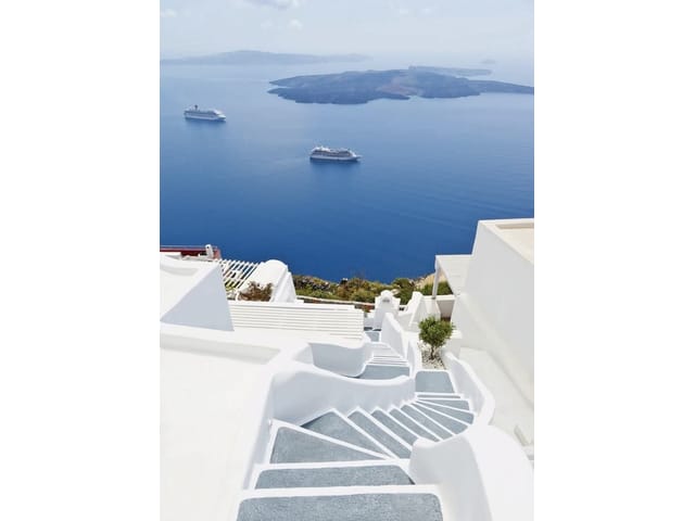 Fototapeta z białymi schodami i widokiem na błękitne morze oraz wyspy