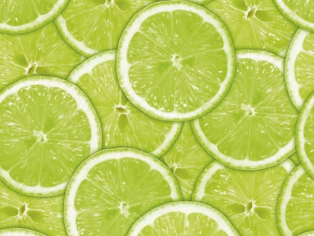 Fototapeta z plasterkami zielonej limonki na stosie, jasnozielony kolor