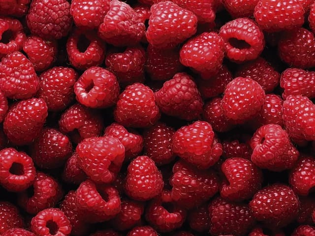 Fototapeta z intensywnie czerwonymi malinami, wypełniającymi cały kadr.