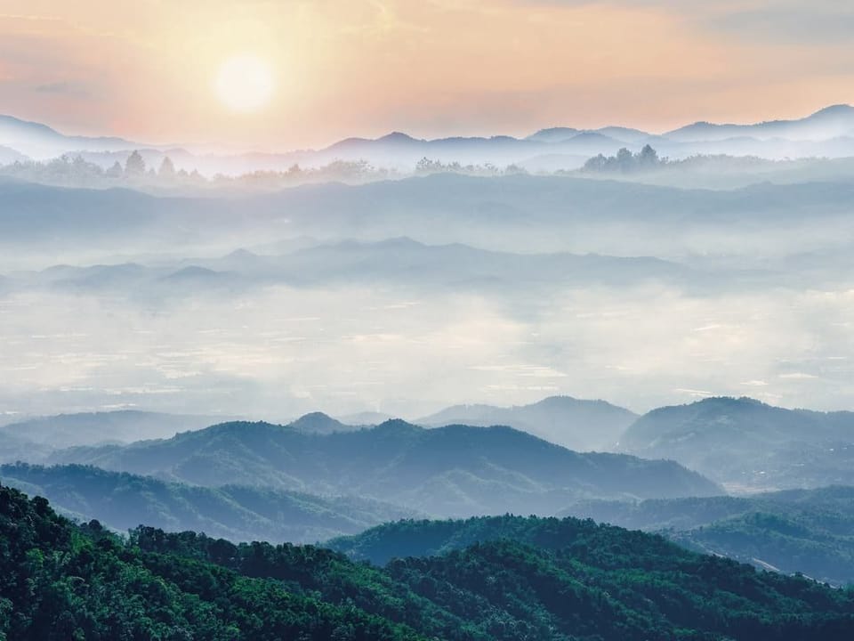 Fototapeta Górski krajobraz z mgłą o zachodzie