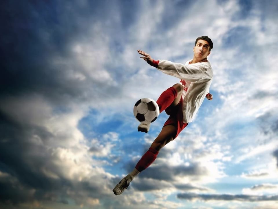 Fototapeta Piłkarz w akcji na tle chmur