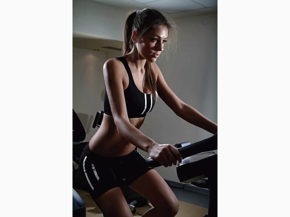 Fototapeta Kobieta na rowerze w siłowni