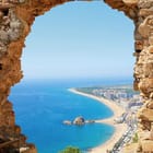 Miniatura fototapety Widok na plażę przez kamienny łuk