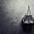 Miniatura fototapety Czarne rękawice bokserskie na ścianie