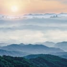 Miniatura fototapety Górski krajobraz z mgłą o zachodzie