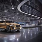 Miniatura fototapety Złoty samochód na nowoczesnym parkingu