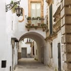 Miniatura fototapety Urokliwa uliczka z łukiem