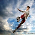 Miniatura fototapety Piłkarz w akcji na tle chmur