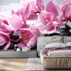 Miniatura fototapety Różowe orchidee na kamieniach we wnętrzu sypialni