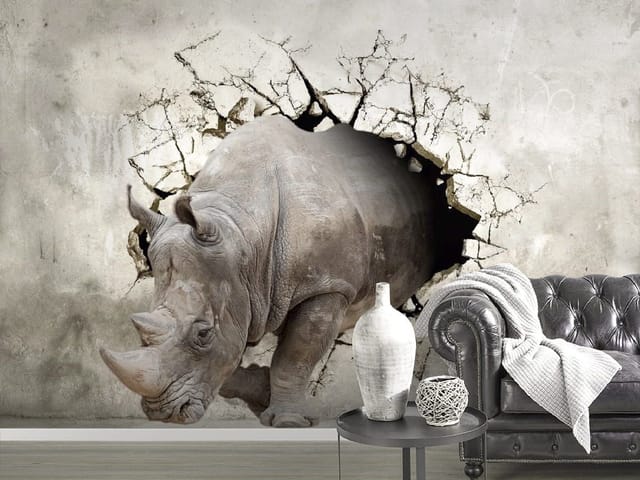 Fototapeta z nosorożcem wychodzącym przez pękającą ścianę na szarym tle