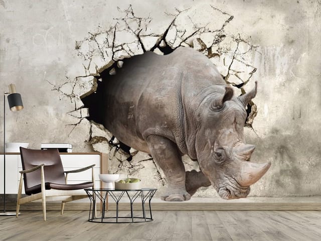 Fototapeta z nosorożcem wychodzącym przez pękającą ścianę na szarym tle