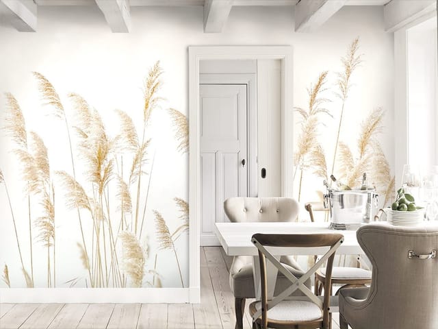 Fototapeta z wysokimi trawami na tle jasnego nieba, delikatnie poruszanymi przez wiatr.