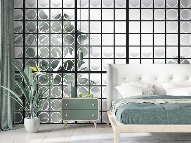 Fototapeta z zielonymi liśćmi za szklaną ścianą z okrągłymi panelami